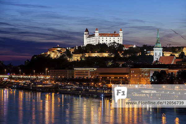 Slowakei  Bratislava  Stadt in der Abenddämmerung mit beleuchteter Bratislavaer Burg und St. Martinsdom an der Donau