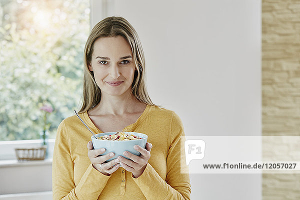 Portrait of woman holding bowl with muesli