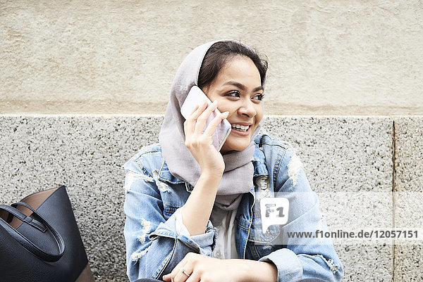 Junge Frau mit Hijab am Handy