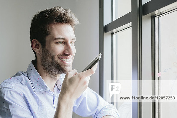 Young businessman working in office using smartphone