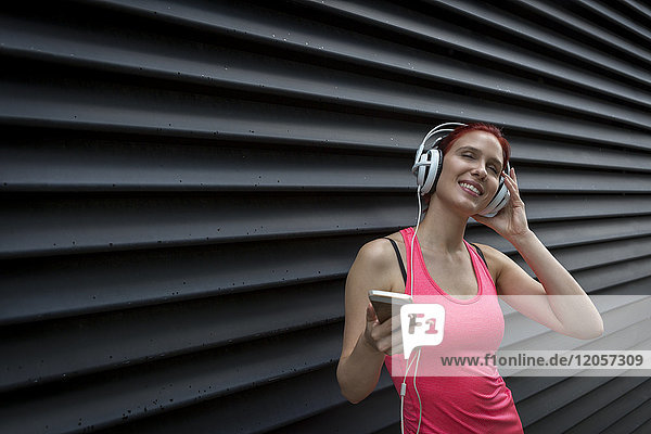 Frau im Sport-Outfit mit Kopfhörer  Musik hören