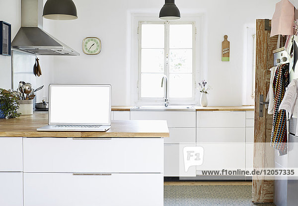 Laptop stehend auf Arbeitsplatte in einer modernen Küche