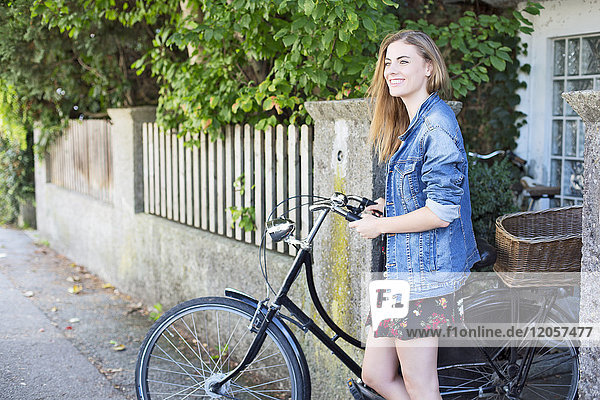 Junge Woan mit Fahrrad in der Stadt