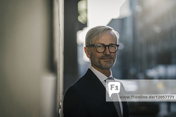 Portrait of grey-haired businessman in the city