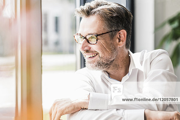 Smiling businessman with glasses looking sideways