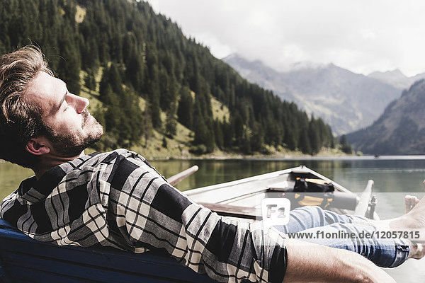 Österreich  Tirol  Alpen  entspannter Mann im Boot auf dem Bergsee
