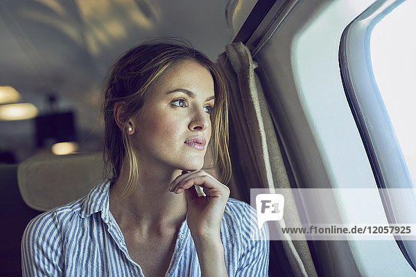 Ernsthafte Frau schaut aus dem Flugzeugfenster