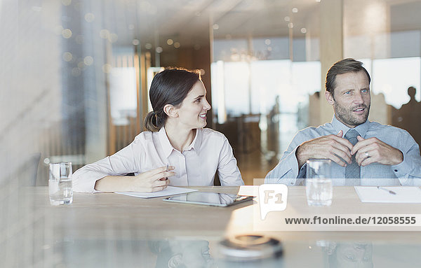 Businesswoman listening to businessman in conference room meeting
