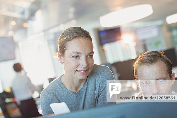 Businessman and businesswoman working at computer in office
