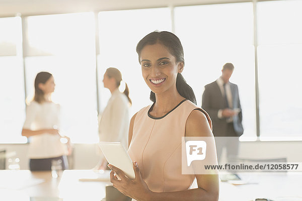 Porträt einer lächelnden  selbstbewussten Geschäftsfrau mit digitalem Tablet in einem Konferenzraum