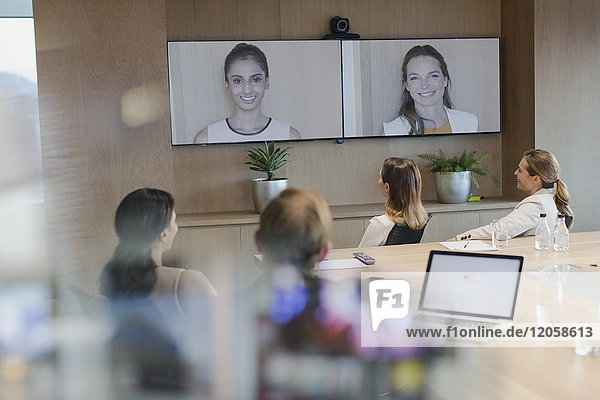 Business people talking on monitors in video conference