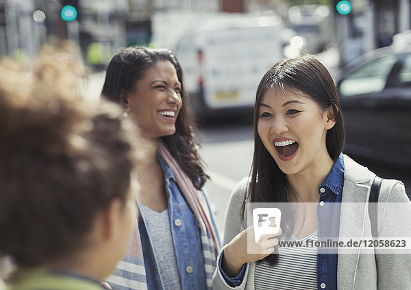 Female friends laughing on urban street