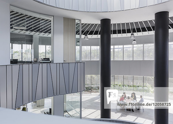 Geschäftsleute treffen sich am Tisch im architektonischen  modernen Büroatrium