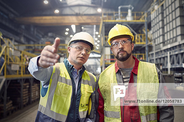 Stahlarbeiter reden  gestikulieren im Stahlwerk
