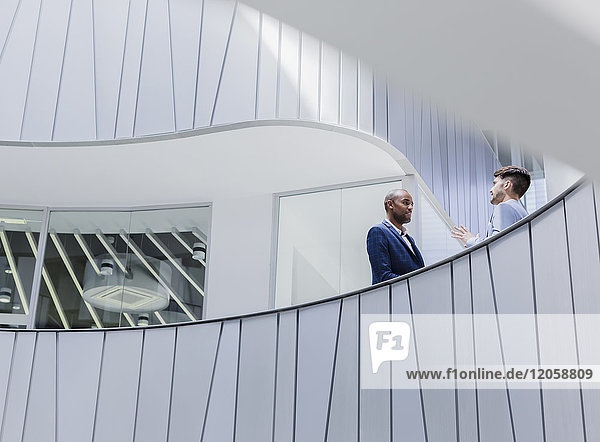 Geschäftsleute im Gespräch auf dem architektonischen  modernen Bürobalkon