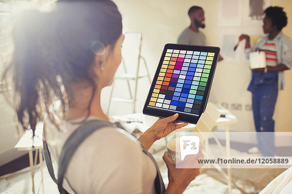 Junge Frau mit digitalem Tablett und digitalen Farbmustern  Malerei Wohnzimmer