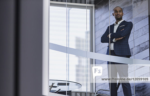Serious  confident CEO businessman standing at modern office window