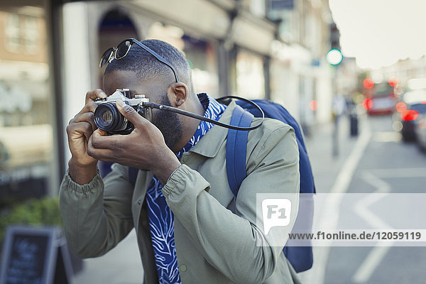 Junge männliche Touristen fotografieren mit Kamera auf der Straße