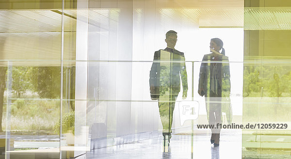 Silhouette Geschäftsmann und Geschäftsfrau zu Fuß im modernen Büroflur