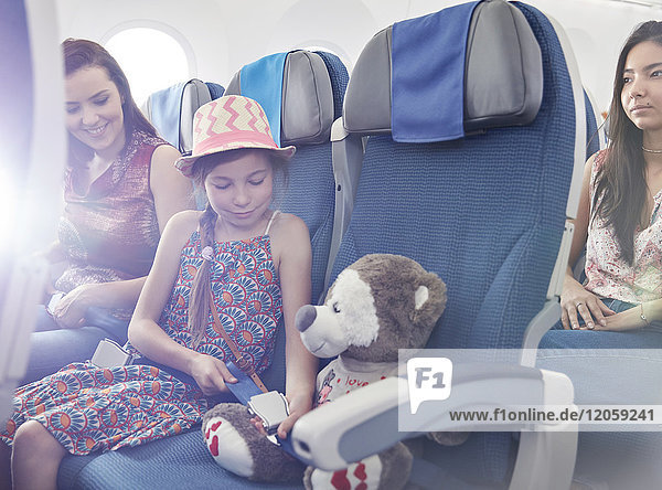 Sicherheitsgurt für Mädchen am Plüschtier im Flugzeug