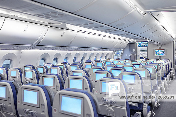 Sitzreihen mit Unterhaltungsbildschirmen im Flugzeug