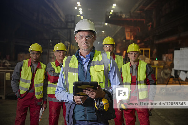 Porträt selbstbewusster Vorgesetzter und Stahlarbeiter im Stahlwerk