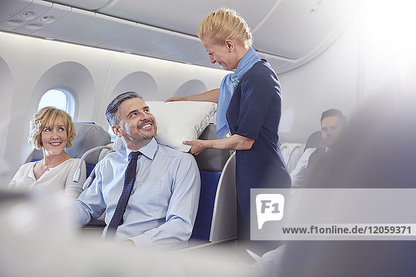 Lächelndes Flugbegleiter-Einstellkissen für Geschäftsleute in der ersten Klasse im Flugzeug