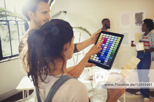 Freunde mit digitalem Tablett zum Betrachten digitaler Farbmuster  Malerei Wohnzimmer