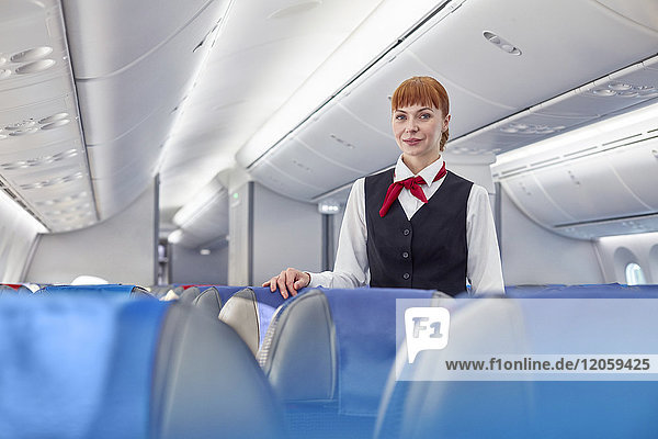 Porträt einer selbstbewussten Flugbegleiterin im Flugzeug