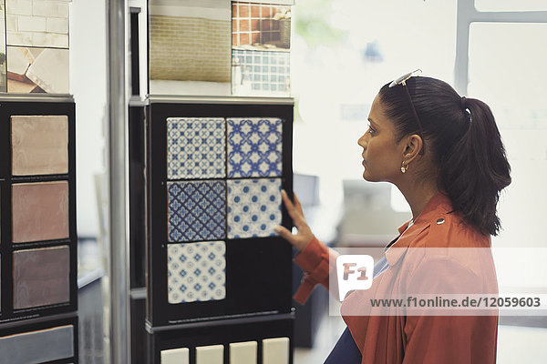 Woman browsing tile samples in home improvement store