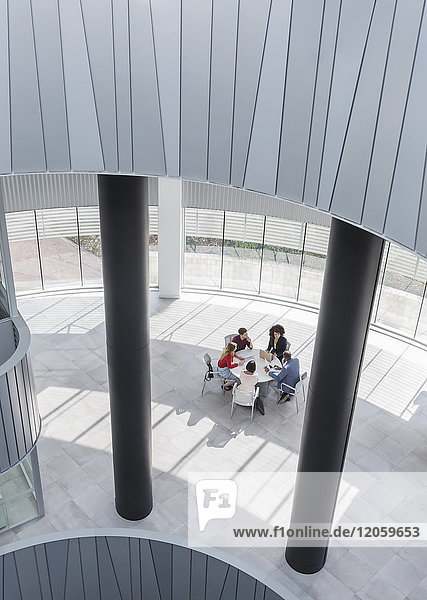 Business people meeting at table in modern office atrium