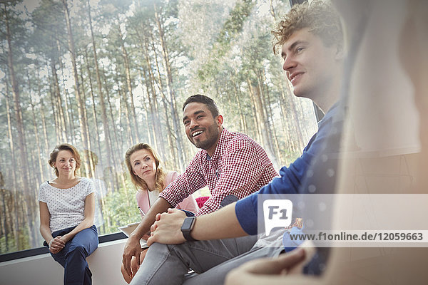 Lächelnde Menschen beim Zuhören in der Gruppentherapie