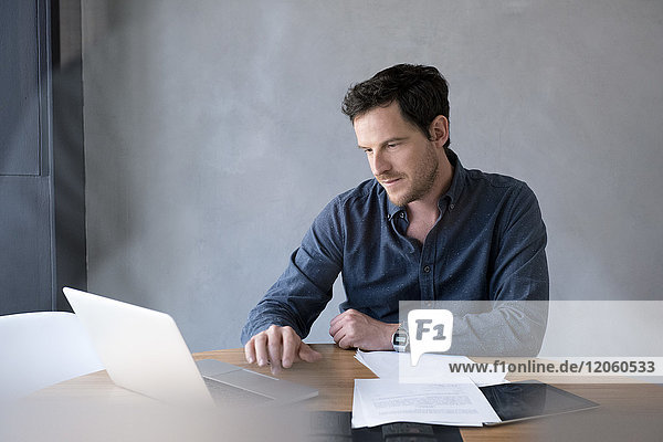 Mann mit Laptop im Büro
