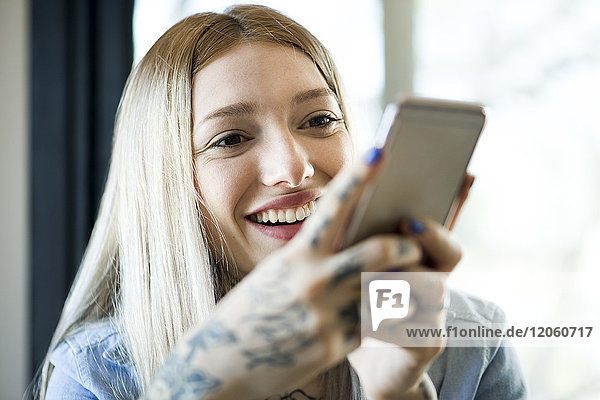 Frau benutzt Smartphone und lächelt fröhlich