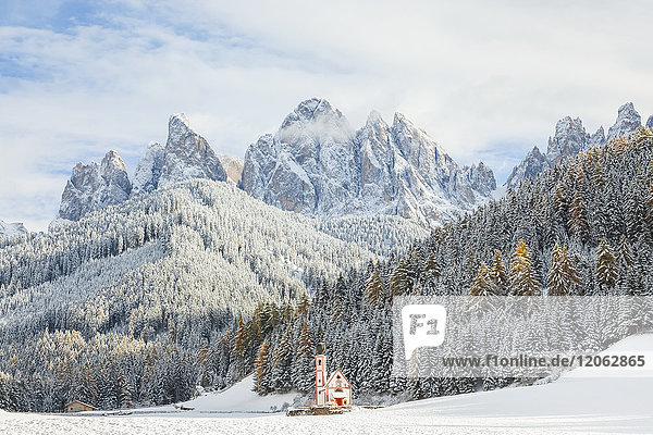 Winter landscape with church,  forest and snow-capped mountains.