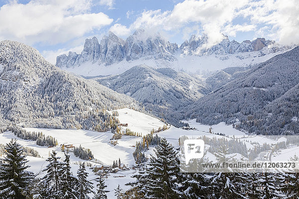 Winterlandschaft mit Tal Wald und schneebedeckten Bergen.