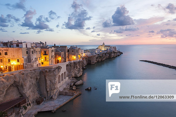Hochwinkelansicht von traditionellen Häusern  die bei Sonnenuntergang auf einer Klippe am Mittelmeer gebaut wurden.