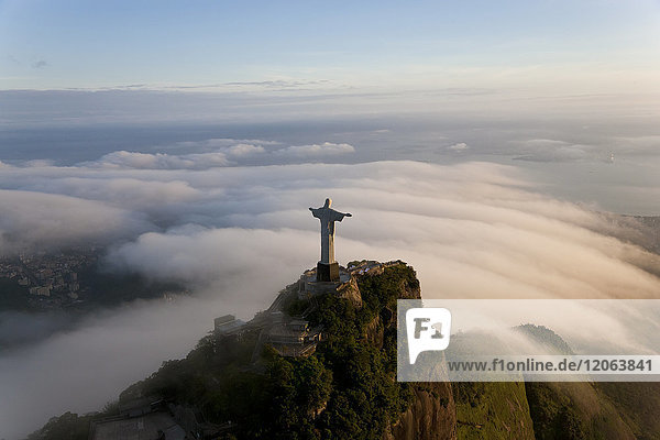High angle view of colossal Christ Redeemer statue surrounded by clouds  Corcovado  Rio de Janeiro  Brazil.