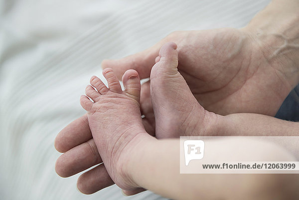 Nahaufnahme einer Mutter  die die Füße ihres neugeborenen Babys hält