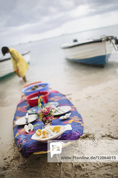 Surfing board decorated as a table with plates  food and flowers