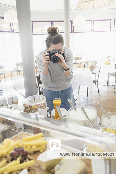 Frau  die das Frühstücksbuffet fotografiert
