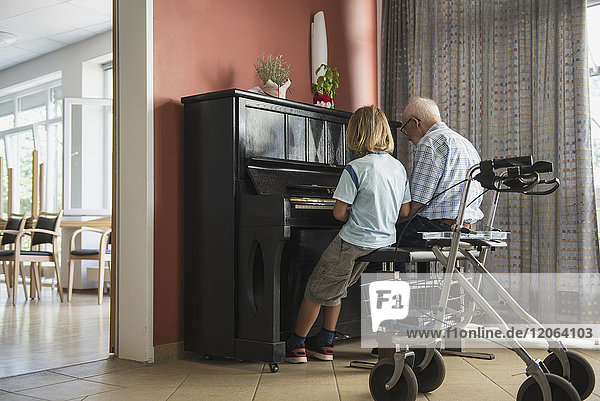 Großvater bringt seinem Enkel ein Klavierinstrument bei