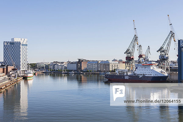 Boot im Hafen mit Wohngebäuden auf der anderen Seite des Flusses  Helsinki  Finnland