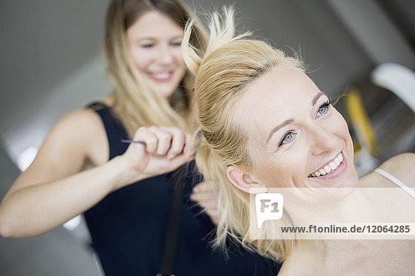 Friseurin kämmt Mode-Modelle Haare im Salon