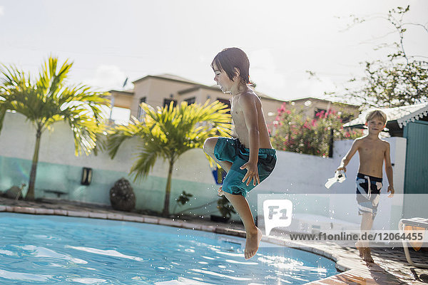 Kleiner Junge springt in den Pool