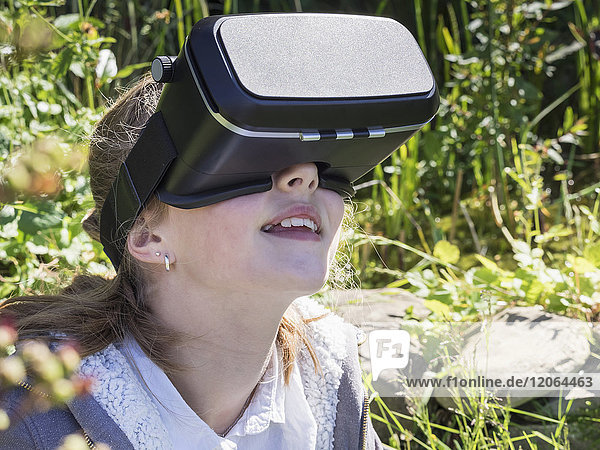 Mädchen mit Virtual-Reality-Headset im Garten