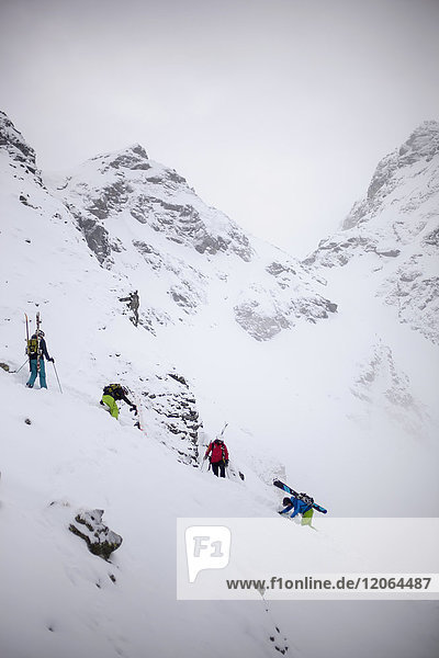 Skitour group climbing snow covered mountain