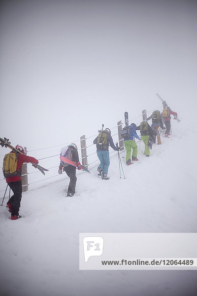 Gruppe von Skifahrern mit Skiausrüstung auf der Piste
