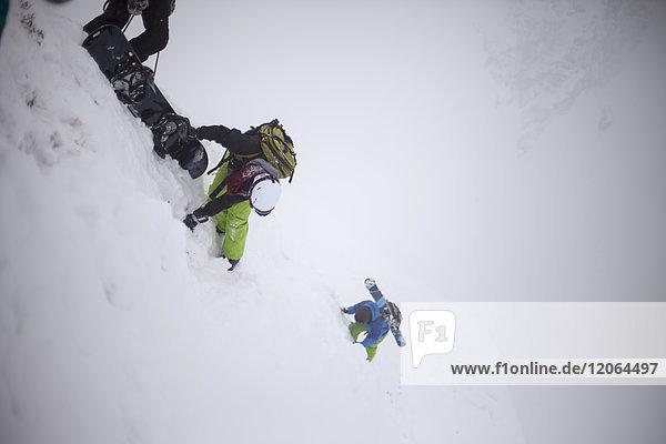 Skiers climbing snowcapped mountain