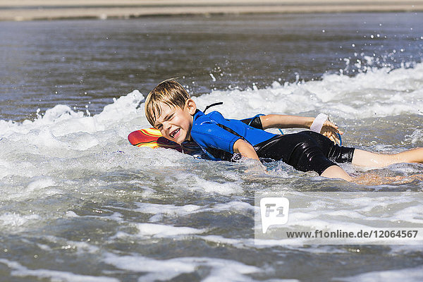 Porträt eines Jungen  der auf dem Meer surft